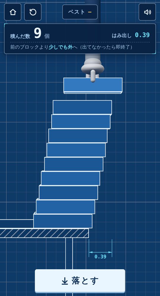 プレイ中の画面。机の端から右へ少しずつずらして積んだ9個のブロックの上で、白い手袋の手が次のブロックを持っている